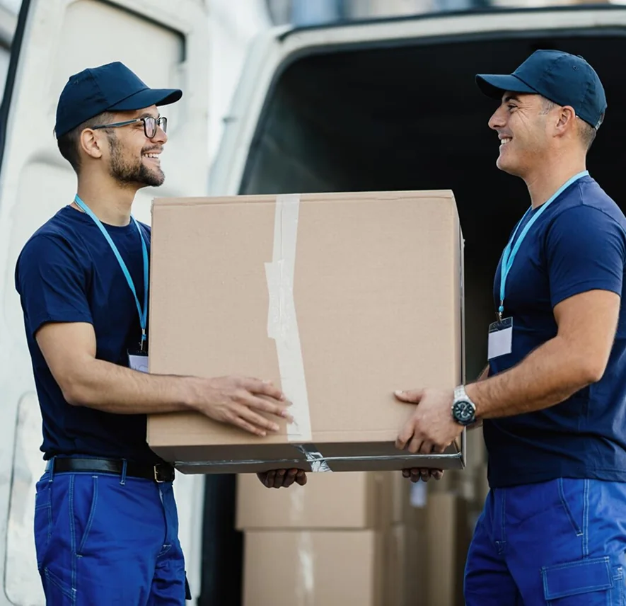 Two CBD Movers removalists loading boxes into a van outside a home