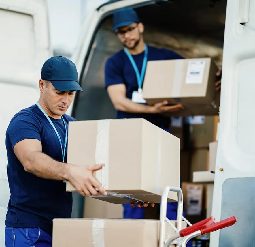 Two CBD Movers removalists loading boxes into a van outside a home