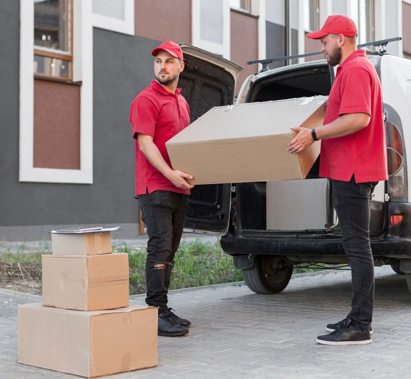 Two CBD Movers removalists loading boxes into a van outside a home