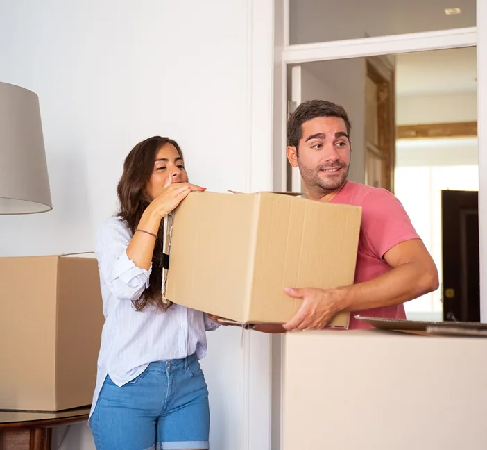Two CBD Movers removalists loading boxes into a van outside a home