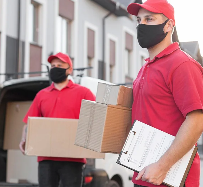 Two CBD Movers removalists loading boxes into a van outside a home